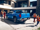 Blue Volkswagen Amarok with family playing beside it